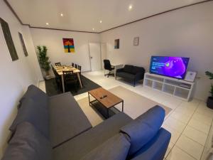 a living room with a couch and a tv at Kaiserviertel Gastromeile, City, Messe & Stadionnah in Dortmund