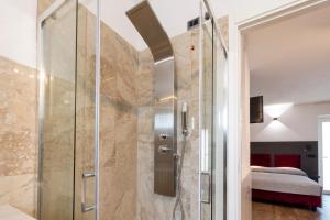 a shower with a glass door in a bedroom at Terre del Mandrolisai in Sorgono