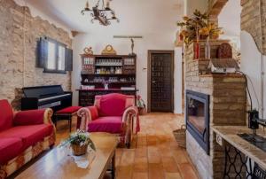 a living room with red furniture and a fireplace at La iaia Merce in L'Aldea