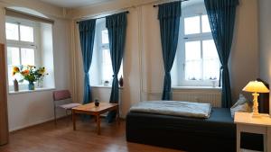 a bedroom with a bed and a table and two windows at Gwuni's Farm in Geithain