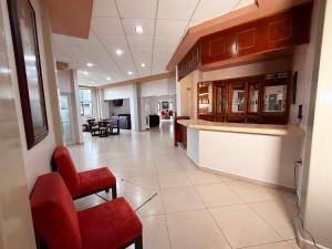 an empty lobby with a red chair and a counter at Rolovi Hotel Xalapa Centro in Xalapa