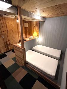 two bunk beds in a room with a table at noctarium in Gotemba