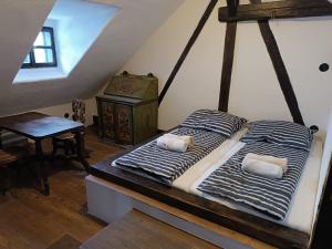 two twin beds in a room with a attic at Krumlovské domky in Český Krumlov