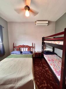 a bedroom with two bunk beds and a ceiling fan at Qué onda! in Ubatuba