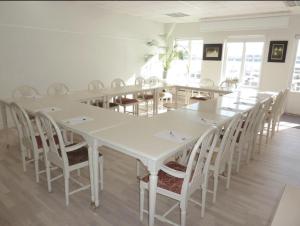 a dining room with white tables and chairs at Mockelsnas Herrgard in Diö