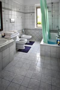 a bathroom with two toilets and a tub and a sink at Torre Ancinale in Soverato Marina