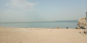 a group of people on a beach near the ocean at Beachside Vacation House in Ras al Khaimah