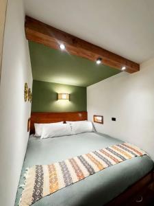 a bed in a room with a green wall at Private Room With Jacuzzi, Pool, and Sauna. in San Lucas Tolimán