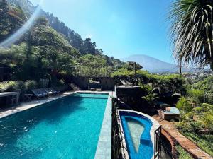 a swimming pool with a mountain in the background at Private Room With Jacuzzi, Pool, and Sauna. in San Lucas Tolimán