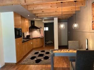 a kitchen with wooden cabinets and a table with a rug at Lucky luke's hideaway in Heibloem