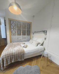 a bedroom with a large white bed and a glass table at Le Royal Dijonnais - Centre Ville in Dijon