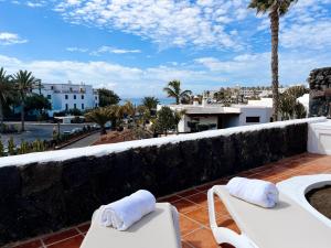 a balcony with two chairs and a view of the ocean at Casa Buna Colorada in Playa Blanca