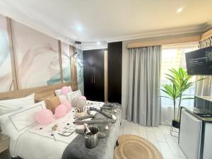 a hotel room with a bed and a tv at Africa Prestige Boutique Hotel in Benoni