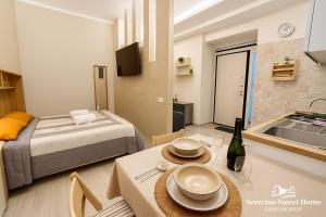 a room with a bed and a table and a kitchen at Severino Sweet Home Casa Vacanze in Mercato San Severino