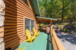 a porch of a wooden house with two yellow chairs at Tranquil Timber by Railey Vacations in Swanton