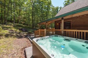 a hot tub on the deck of a log cabin at Tranquil Timber by Railey Vacations in Swanton