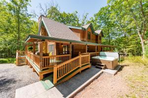 a log cabin with a large deck and a hot tub at Tranquil Timber by Railey Vacations in Swanton +15 photos