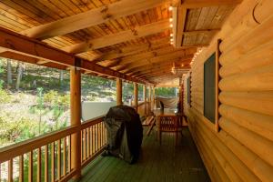 a porch of a log cabin with awning and a table at Tranquil Timber by Railey Vacations in Swanton