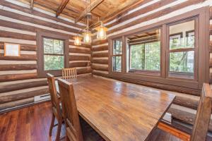 a dining room with a wooden table in a log cabin at Tolson Cabin by Railey Vacations in Oakland