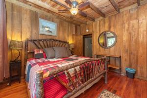 a bedroom with a bed in a room with wooden walls at Tolson Cabin by Railey Vacations in Oakland +22 photos