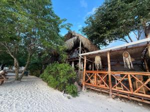 a resort with a thatched building on the beach at Thani Ecobeach Barú in Playa Blanca
