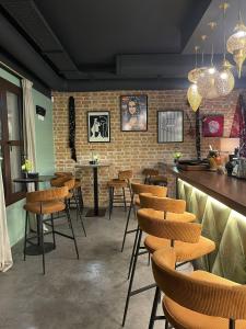 a restaurant with wooden stools and a brick wall at Zazz Estepona in Estepona