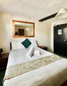 a bedroom with a large white bed with a mirror at Greyfriars Lodge Canterbury in Canterbury