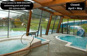 a large pool with a swimming pool and some windows at Luxury B&B August in Ortisei