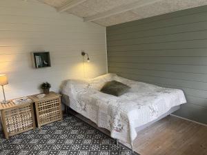 a bedroom with a bed and a table with a lamp at Heltoften Bed & Breakfast in Nykøbing Mors