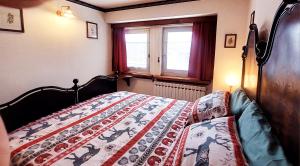 a bedroom with a bed with a quilt on it at Dolce Vista in Passo del Tonale