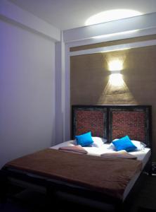 a bedroom with a bed with blue pillows and a light at Wounder Mountain view ella in Medaperuwa