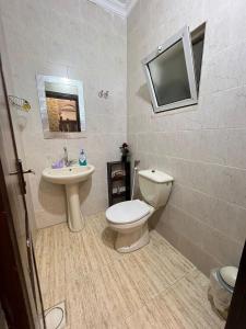 a bathroom with a toilet and a sink and a tv at Jad Apartment in irbid in Irbid