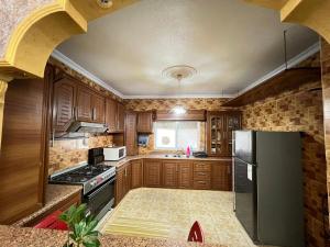 a kitchen with wooden cabinets and a black refrigerator at Jad Apartment in irbid in Irbid