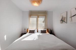 a bedroom with a large white bed in front of a window at Fewo Spectrum in Überlingen