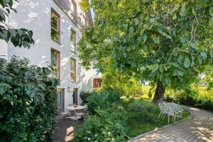 a garden with a table and chairs under a tree at Fewo Spectrum in Überlingen