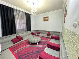 a living room with a large couch with red cushions at Jad Apartment in irbid in Irbid