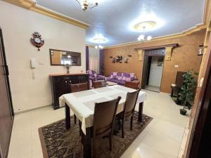 a dining room with a white table and chairs at Jad Apartment in irbid in Irbid +11 photos
