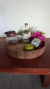 a wooden table with a bottle of alcohol and flowers at Studio tout confort - Hameka in Grand-Bourg