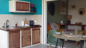 a kitchen and dining room with a table and a table and a dining room at Studio tout confort - Hameka in Grand-Bourg