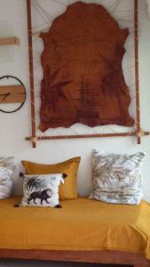 a bed with pillows and a painting on the wall at Studio tout confort - Hameka in Grand-Bourg +2 photos
