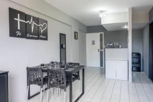 a dining room with a table and chairs and a kitchen at No coração do Recife in Recife