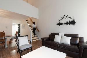 a living room with a couch and a staircase at Unité 26 - Ski-in Ski-out in Beaupré +30 photos