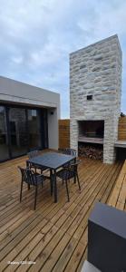 a patio with a table and chairs on a wooden deck at Fynbos N Sea in Gansbaai