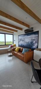 a living room with a couch and a large painting on the wall at Fynbos N Sea in Gansbaai