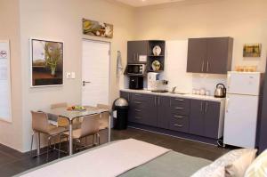 a kitchen with a table and a white refrigerator at Art and Accommodation Guesthouse in Cape Town