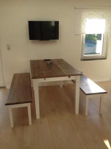 a wooden table and bench in a room with a tv at Ferienwohnung Odessa in Zinnowitz
