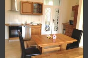 a kitchen with a wooden table and black chairs at Ferienwohnung Fritz in Zinnowitz