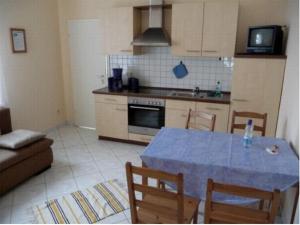 a kitchen with a blue table and chairs in a room at Ferienwohnung Lino in Zinnowitz