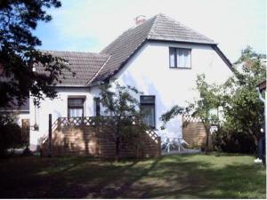a white house with a table and chairs in the yard at Ferienwohnung Annika mit Sauna in Zinnowitz