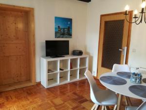a dining room with a table and a television at Ferienwohnung Annika mit Sauna in Zinnowitz